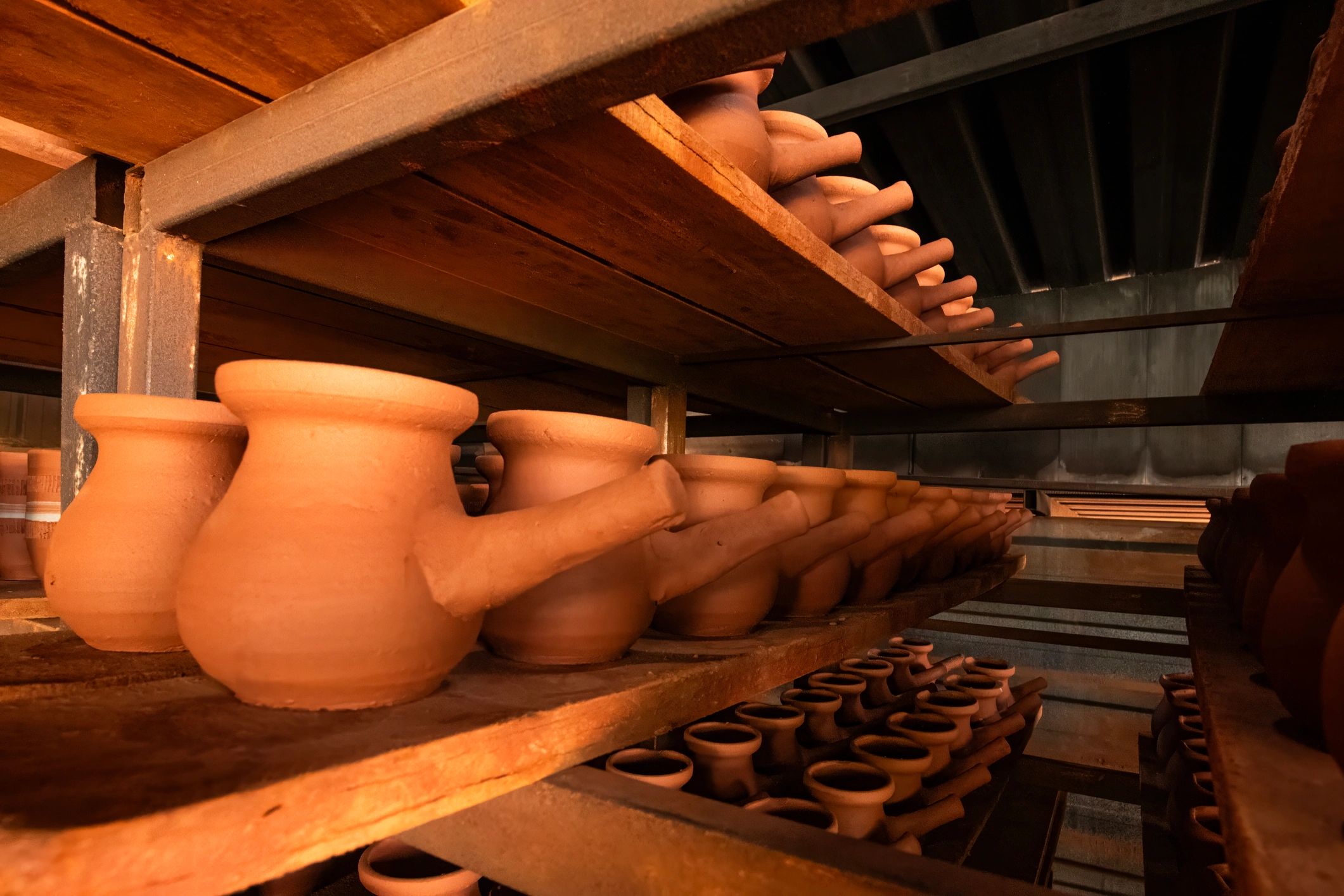 Detalhe das mãos moldando cerâmica artesanal